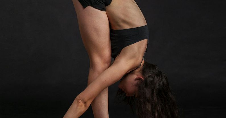 Yoga Poses - Woman Wearing Black Sports Bra Reaching Floor While Standing