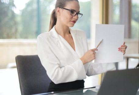 Wellness Plan - Determine female executive manager in formal wear sitting at table with laptop in office and explaining business plan