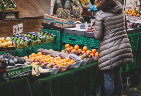 Local Food - Woman Standing in Front of Assorted Fruits Displayed