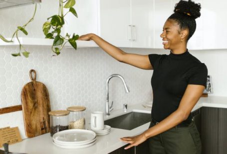 Kitchen Organization - A Smiling Young Woman Organizing her Kitchen