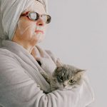 Pet-Safe Holiday - Woman after bath standing with cat in arms