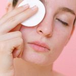 Makeup Removal - Woman removing eye makeup with cotton pad