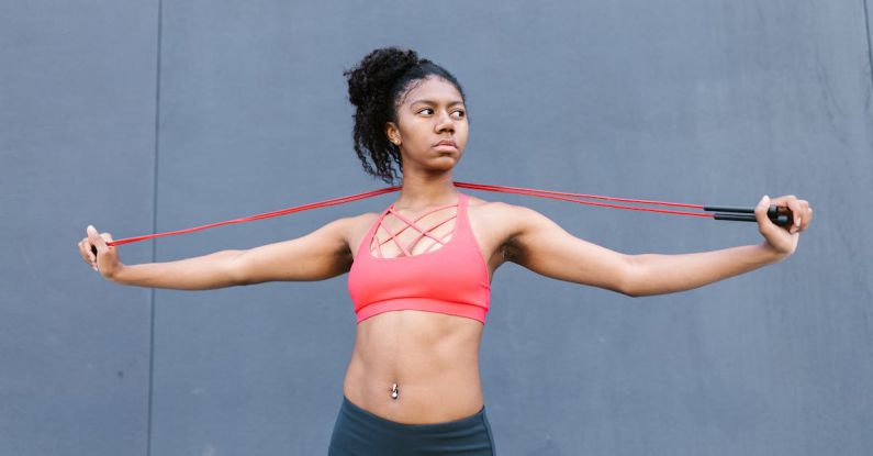 Bodyweight Exercises - Woman in Active Wear Stretching a Rope